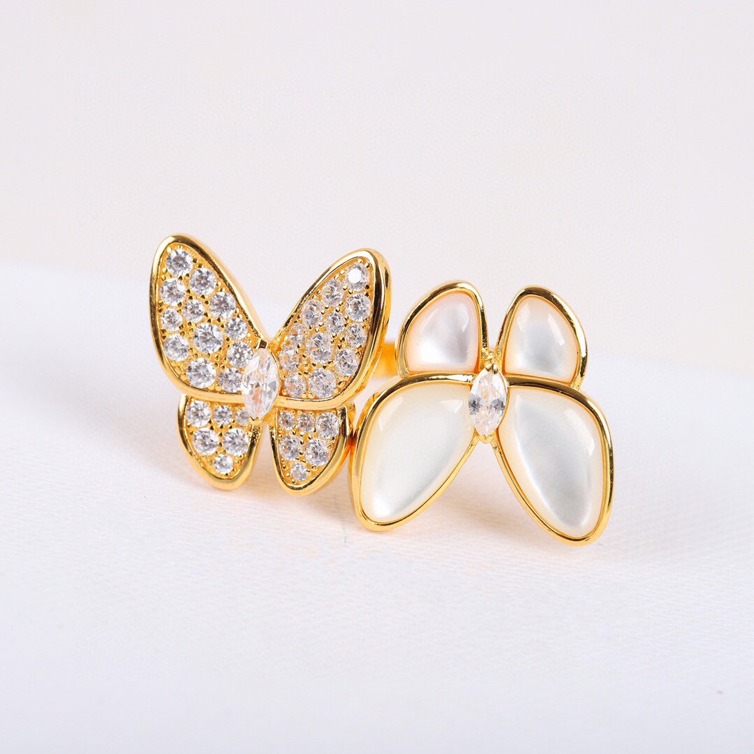 Gold butterfly-shaped brooch with gemstones on a light background
