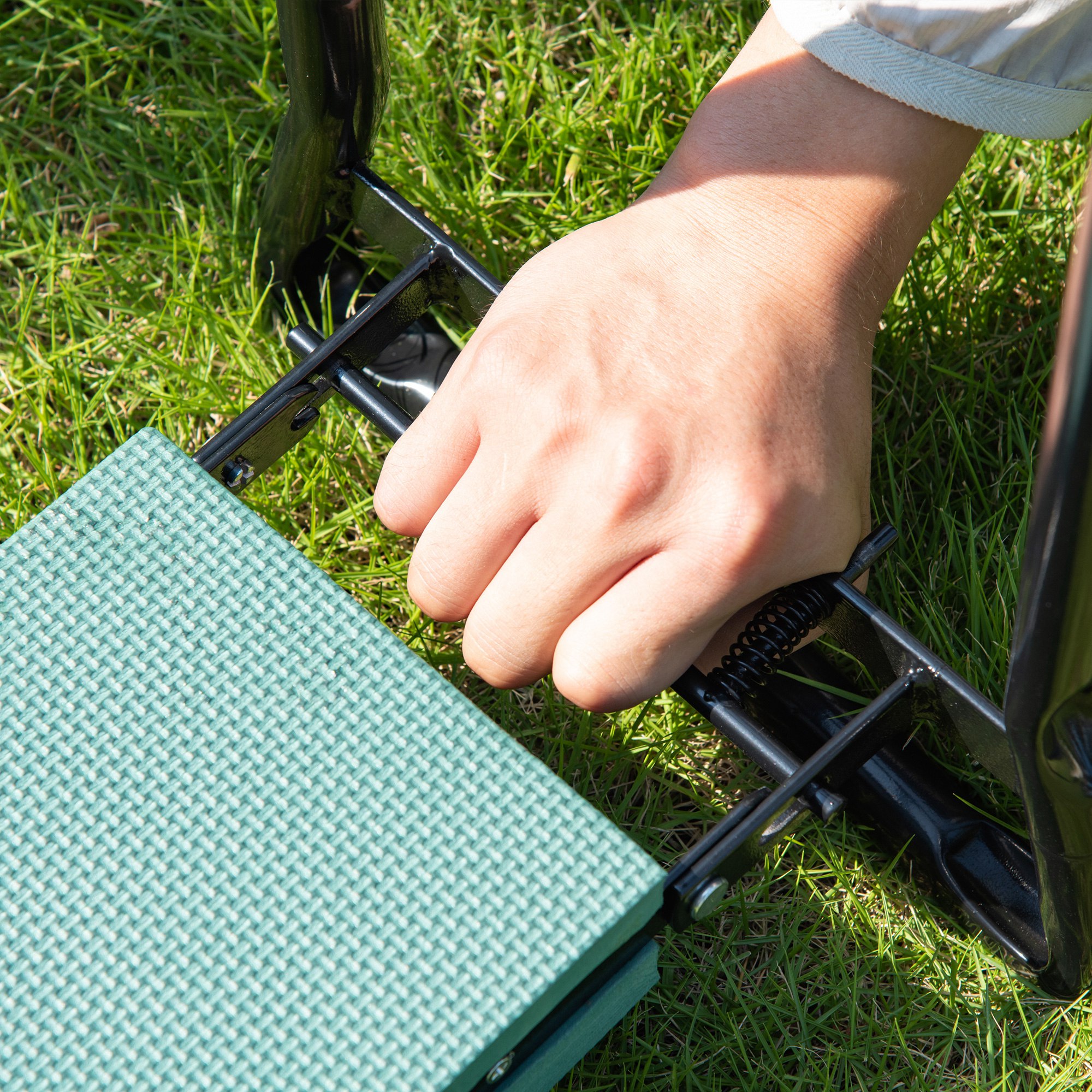 Folded garden kneeler showing compact flat storage size and spring-loaded leg mechanism
