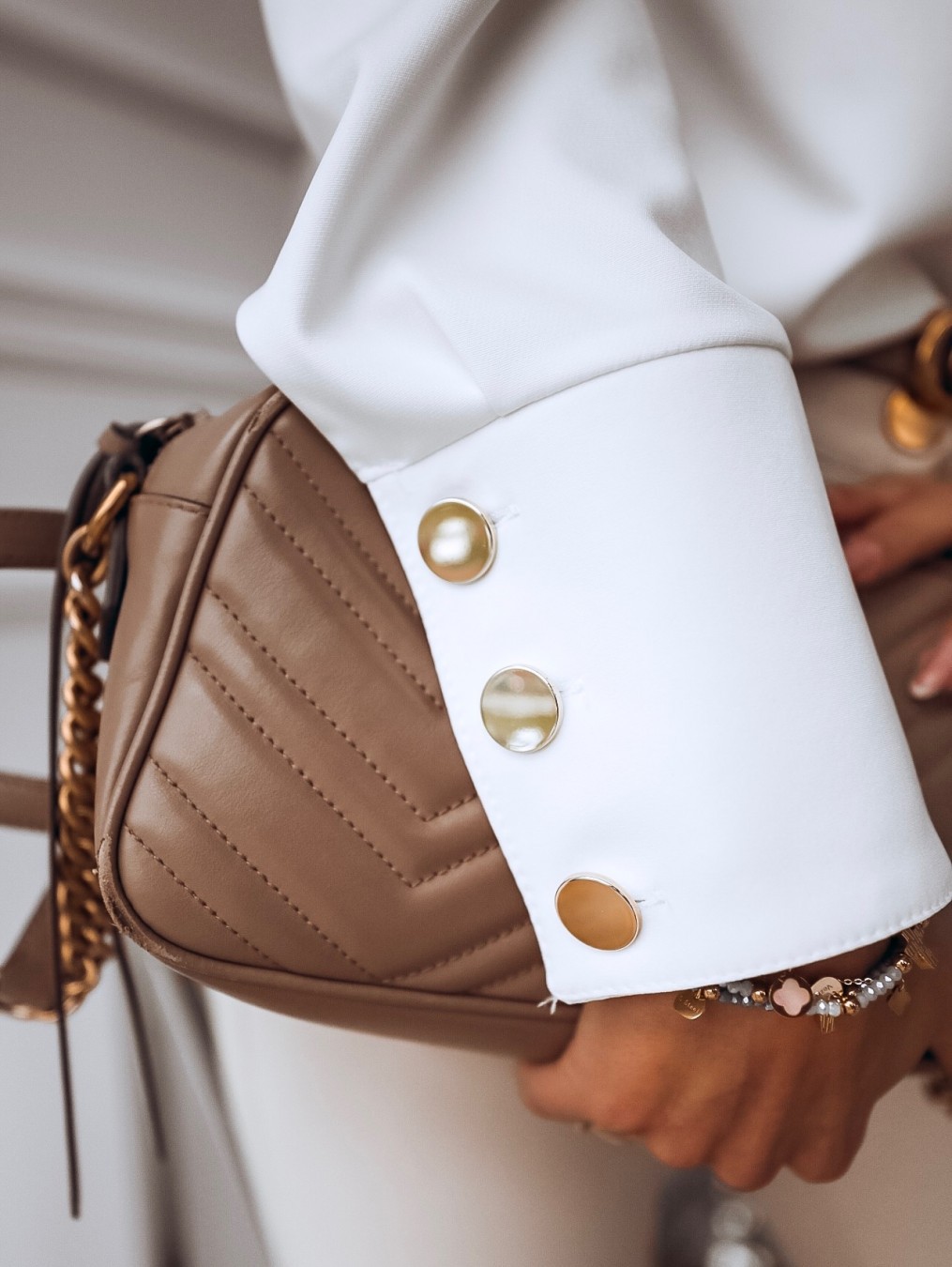 قميص بأكمام طويلة وأزرار معدنية