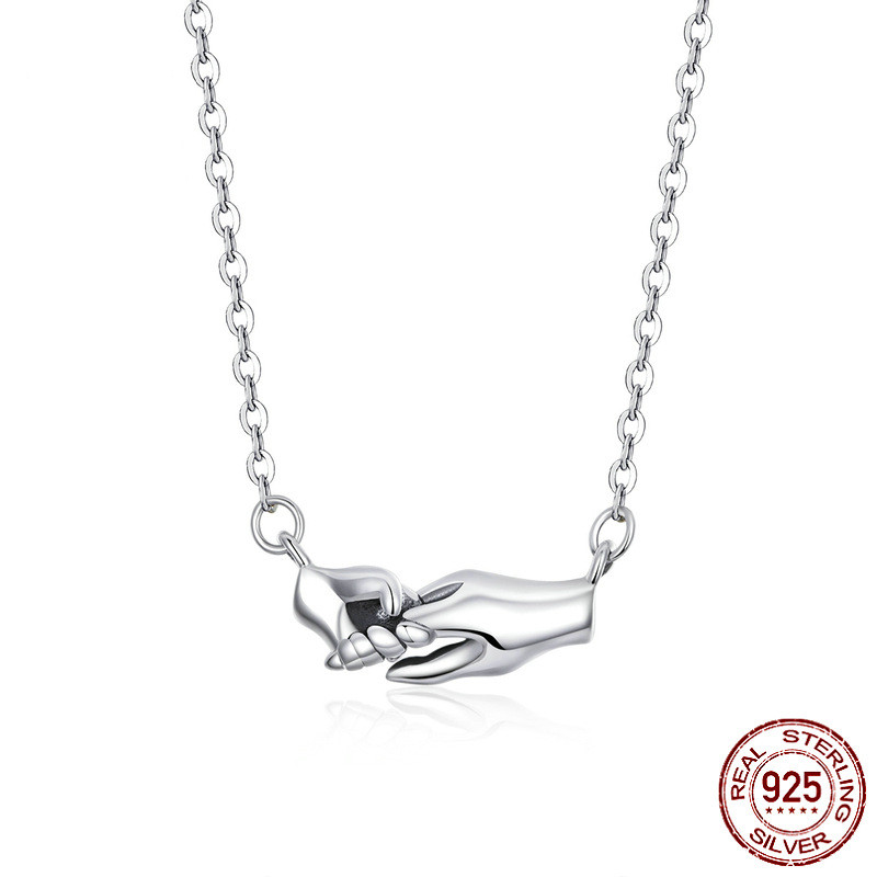 Hands guarding mother's necklace gift