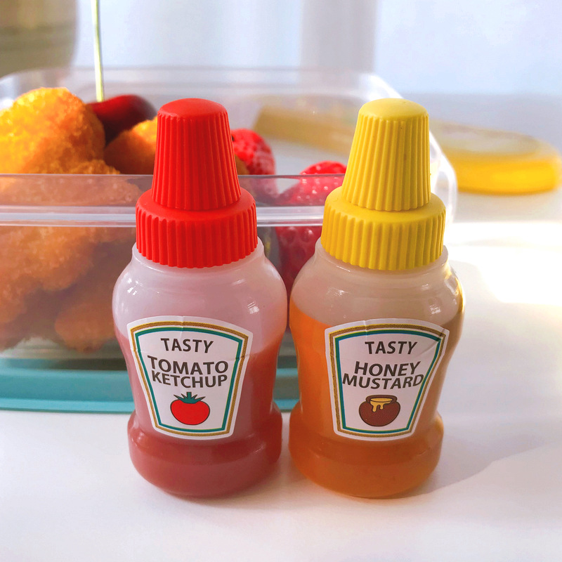 Two portable salad dressing and ketchup bottles