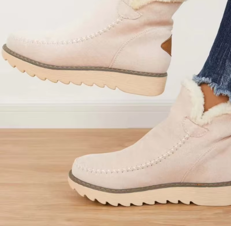 Beige suede-look ankle boots showing moccasin-style toe stitching, plush cuff trim and chunky cream soles
