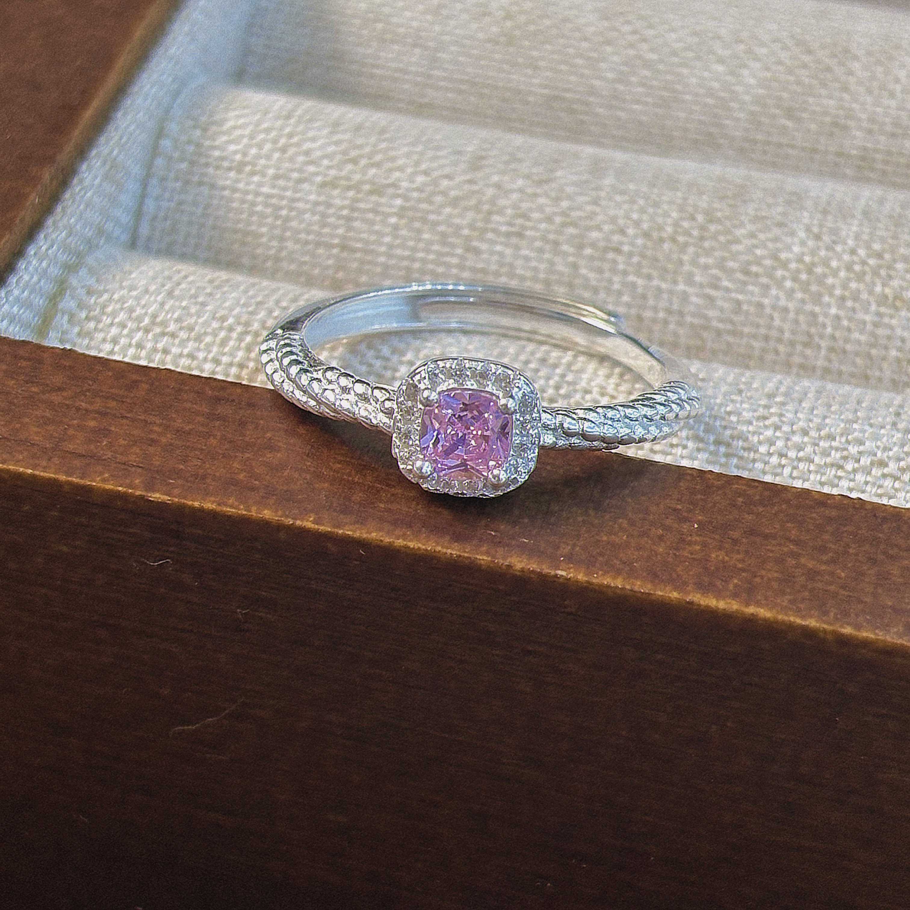 Pink cushion cut CZ sterling silver ring in jewelry display case retail presentation