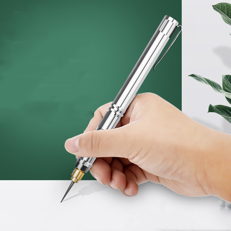 Hand holding a stainless steel high-speed engraving pen with fine needle tip, showcasing its precise, pen-like grip for detailed craftwork.