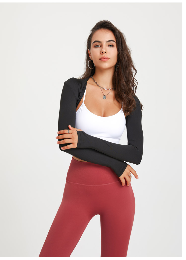 Cropped long sleeve shrug layered over a sports bra