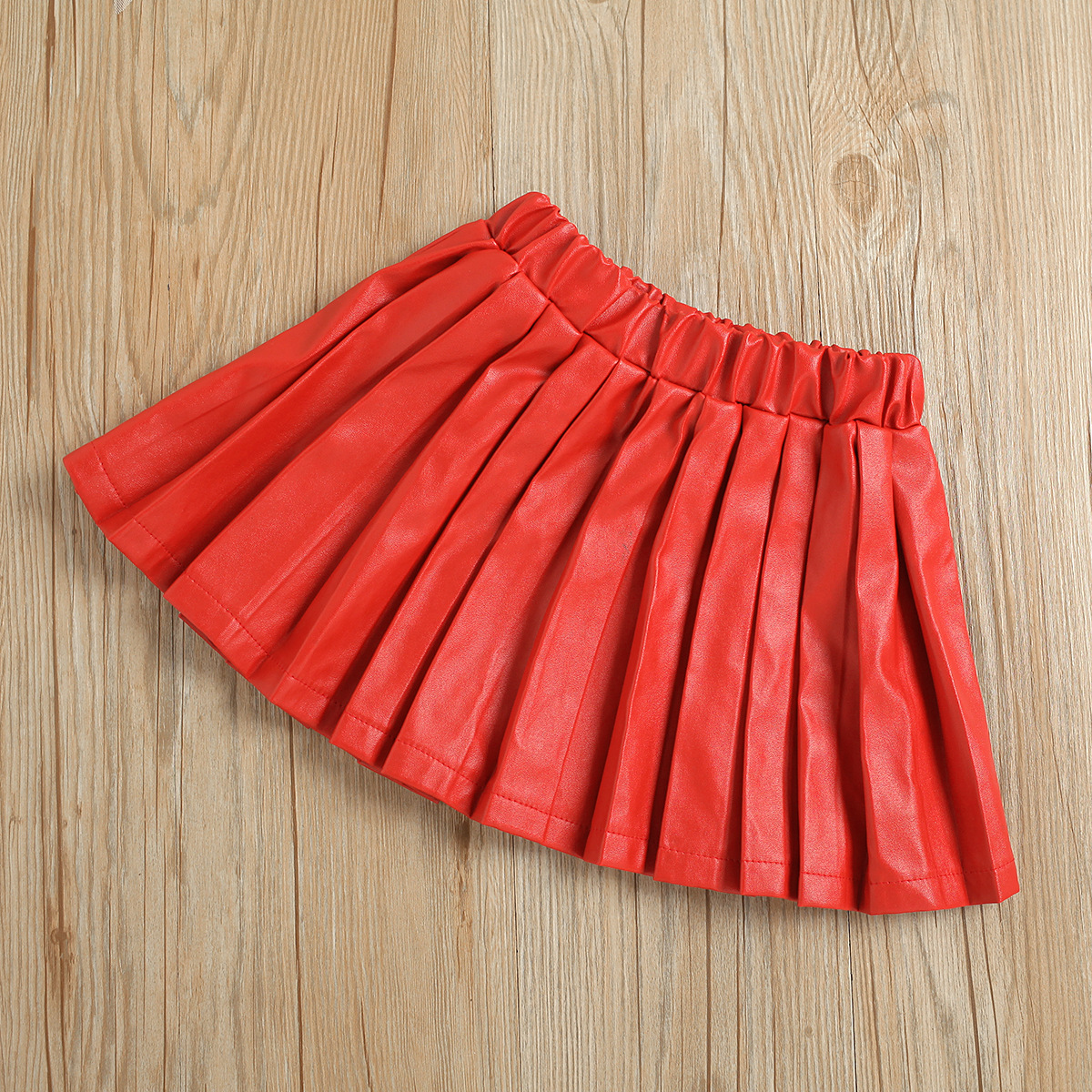 بلوزة كتف واحدة بأكمام طويلة مع تنورة جلدية حمراء مطوية