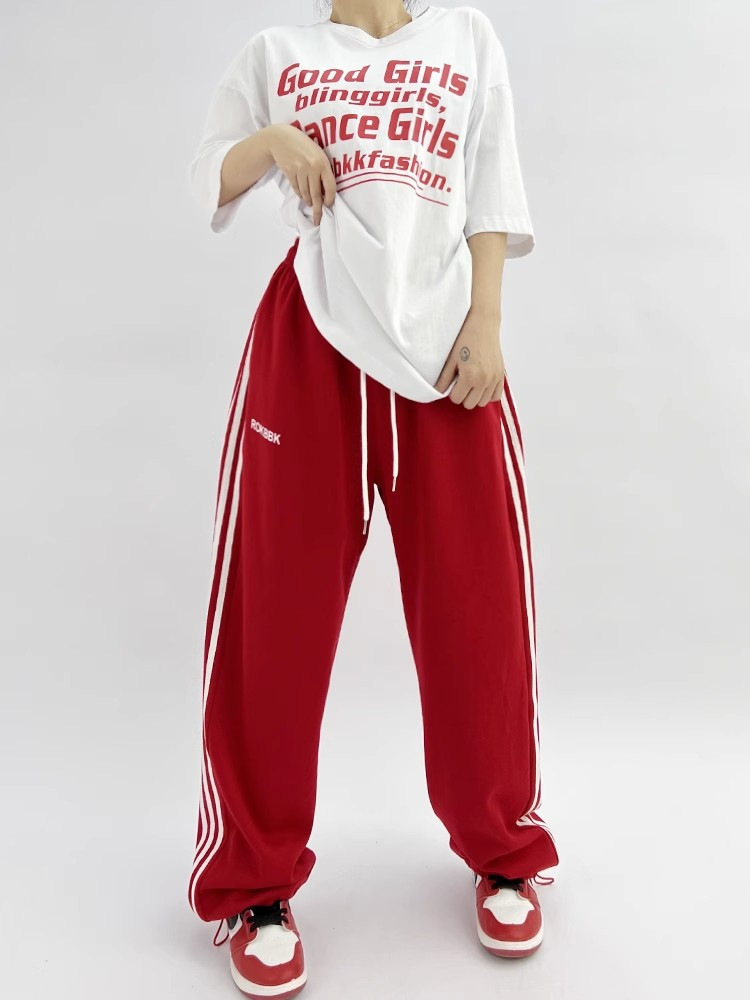 Embroidered patchwork wide-leg sweatpants, lifestyle detail shot showing embroidery and patchwork construction