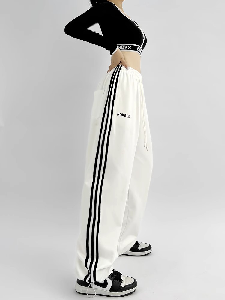 Wide-leg sweatpants, model wearing detail shot showing embroidery and patchwork design