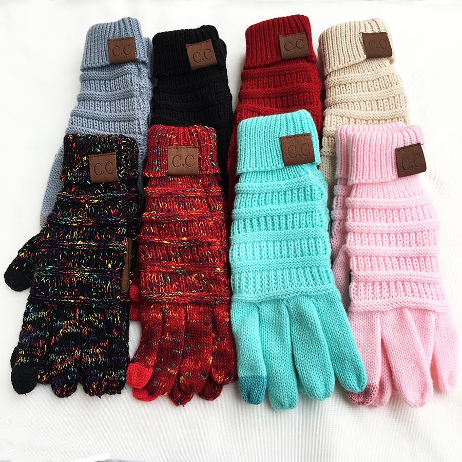 An array of European and American Wool Knitted Turn-over Labeling Touch Screen Gloves is displayed in neat pairs on a white surface. These gloves, made from soft acrylic fiber, are available in an assortment of colors such as gray, black, red, beige, multicolored, blue, and pink. Each pair is adorned with a brown patch featuring the initials "C.C.