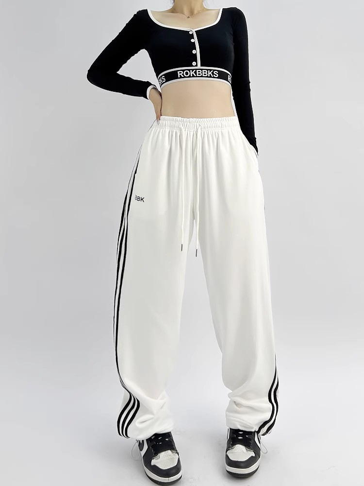 Wide-leg athletic sweatpants, model wearing outdoor lifestyle photo showing full silhouette