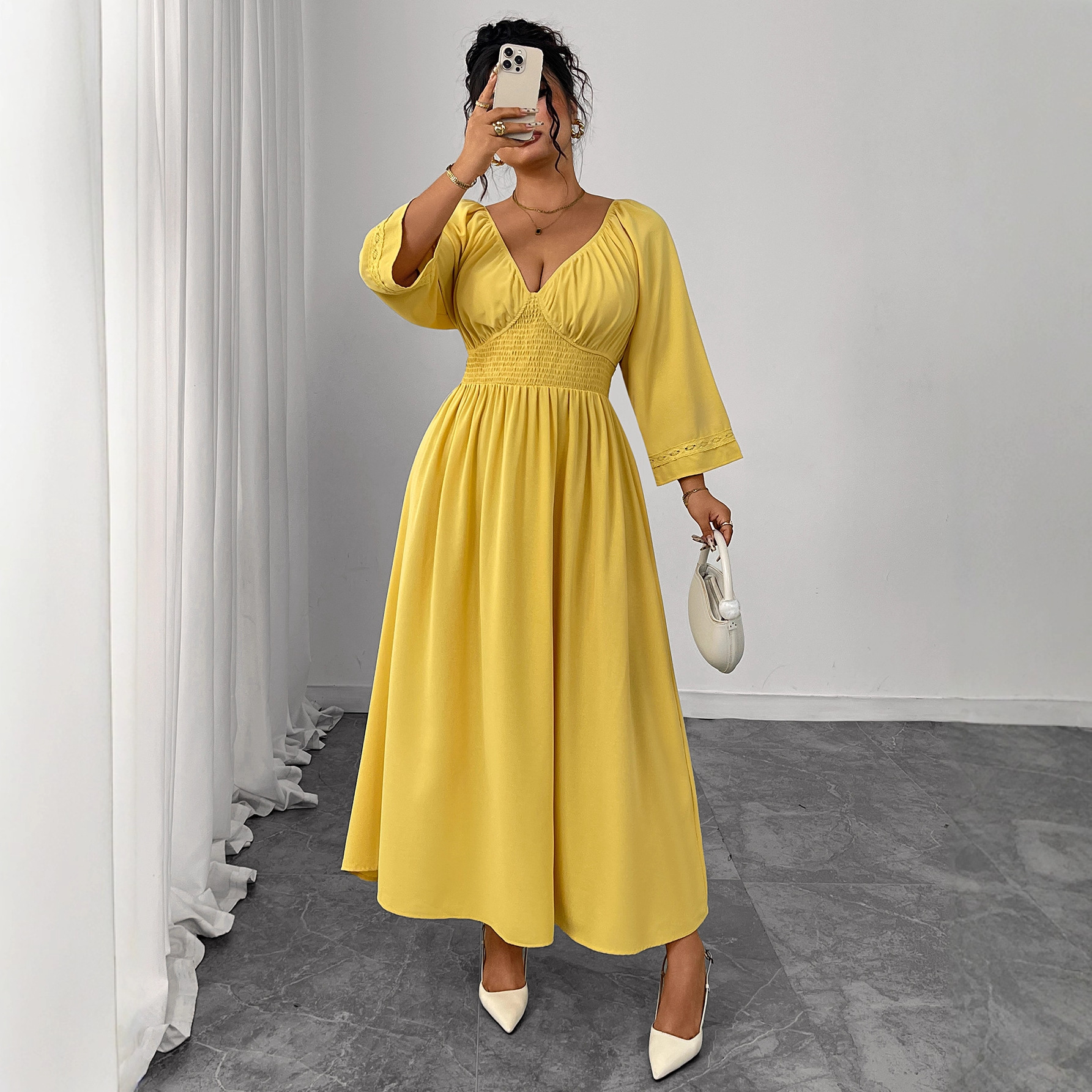 فستان أصفر بخصر عالٍ ورقبة على شكل حرف V عميقة