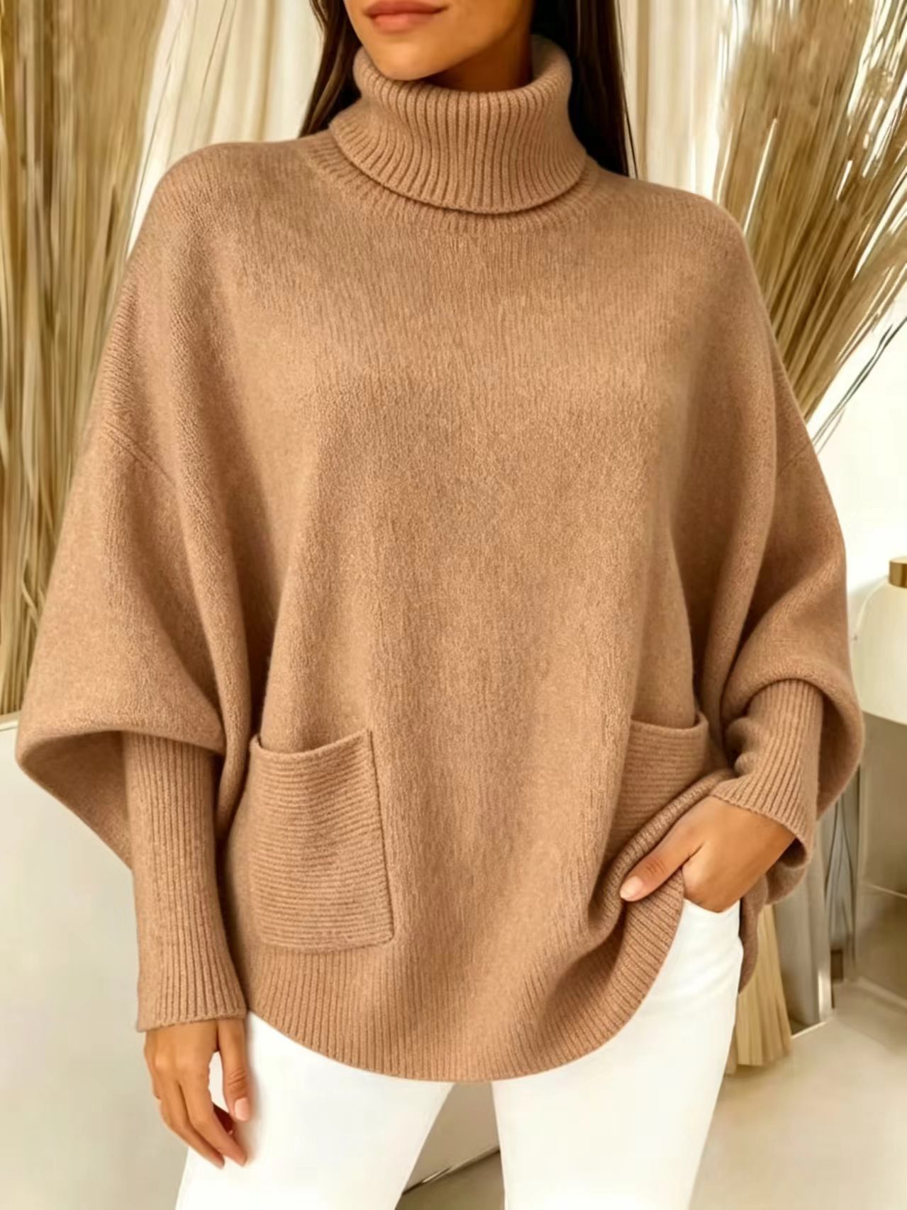 Women's batwing sleeve sweater – back view showing dramatic sleeve drape and curved hem