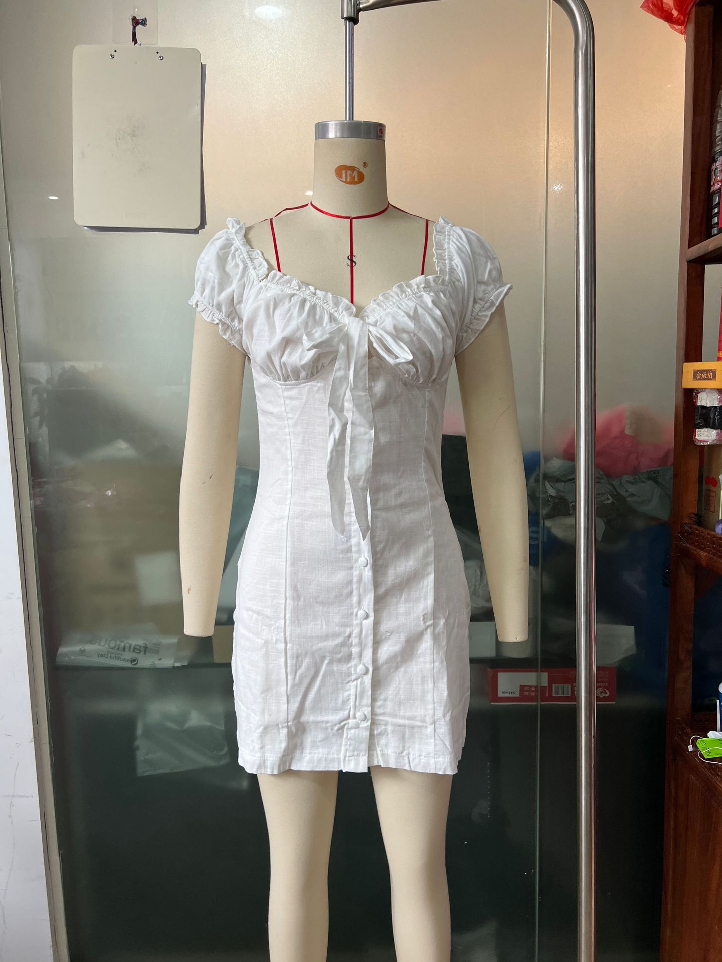 Women's lace-up puff-sleeve sheath dress in white, close-up of off-shoulder neckline and lace-up detail