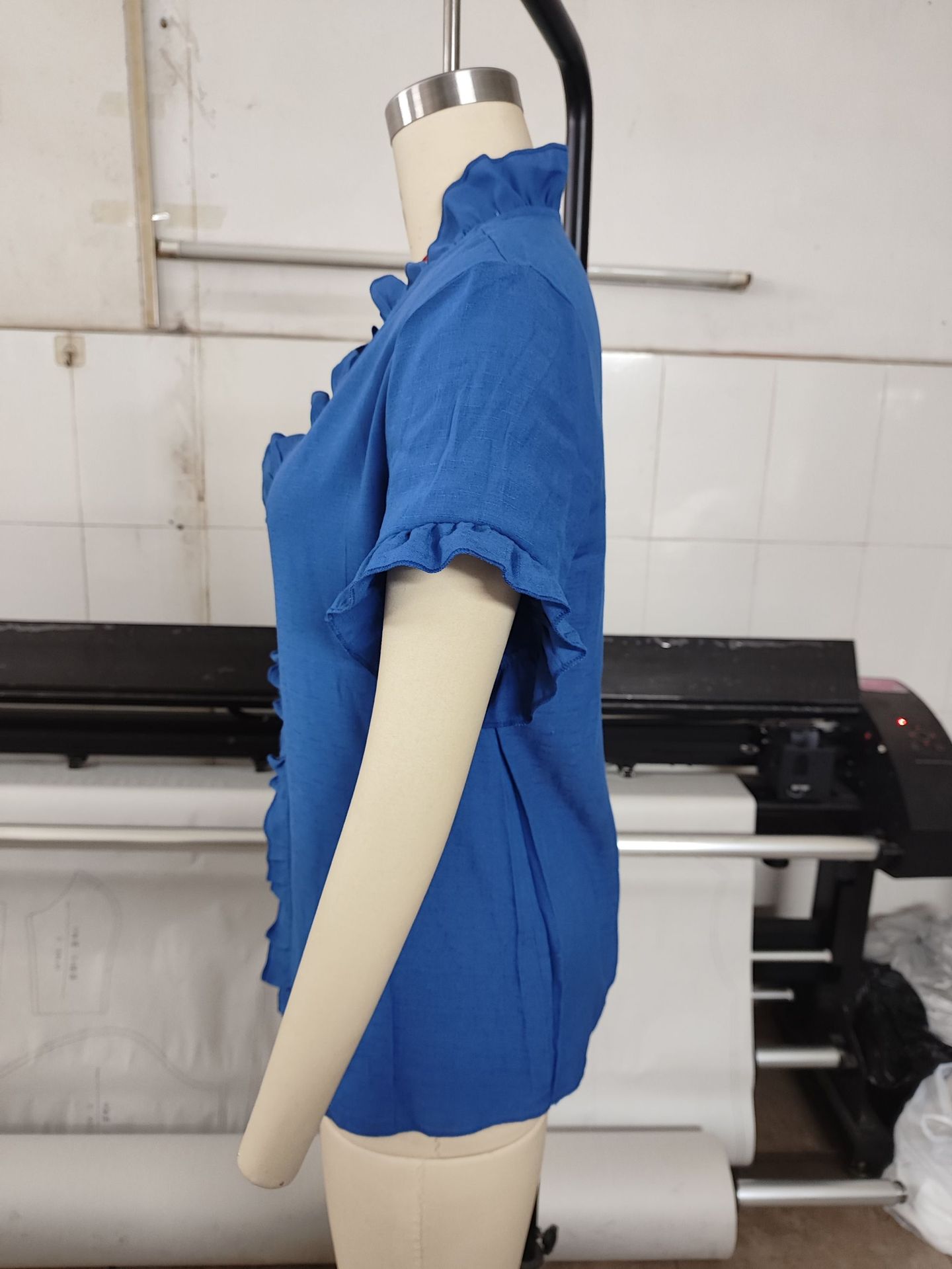 Solid color ruffle top in light blue, close-up of ruffle sleeve and V-neckline detail
