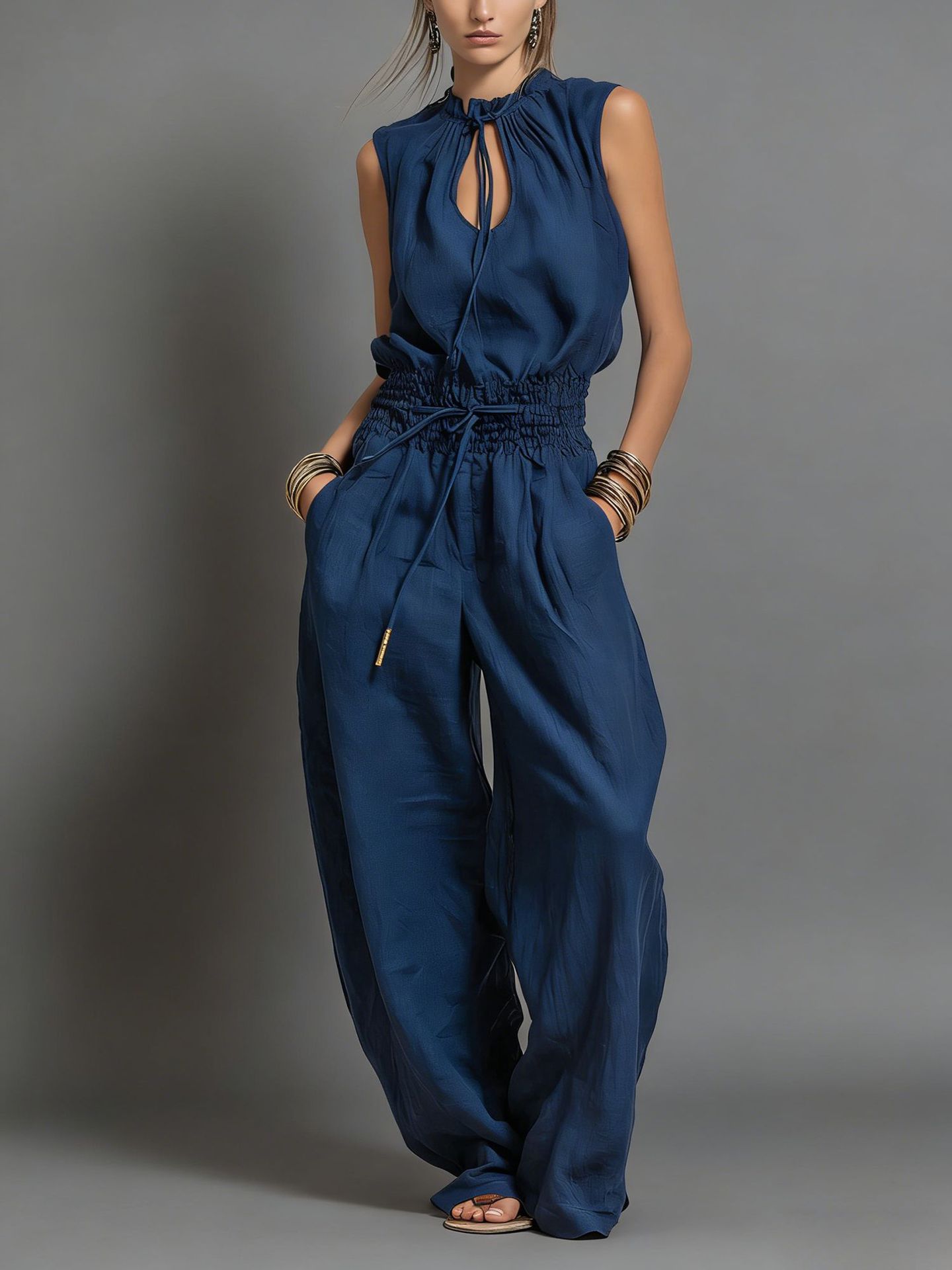 Women's sleeveless high-waist wide-leg pleated jumpsuit in black, front view showing full silhouette
