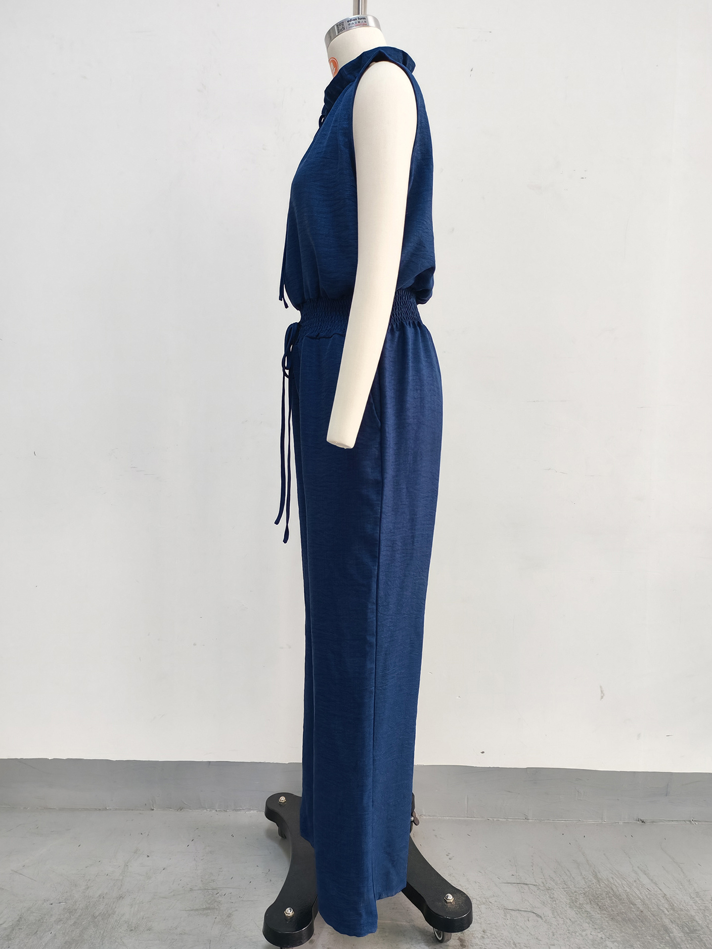 Women's high-waist wide-leg jumpsuit in blue, full outfit view showing pleated detail